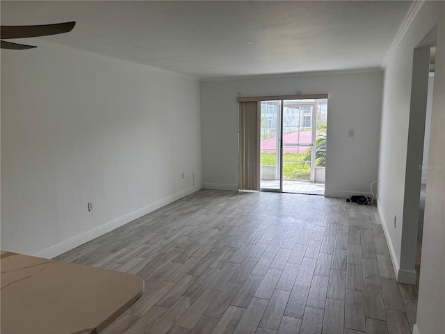 unfurnished room featuring crown molding, a ceiling fan, wood finished floors, and baseboards