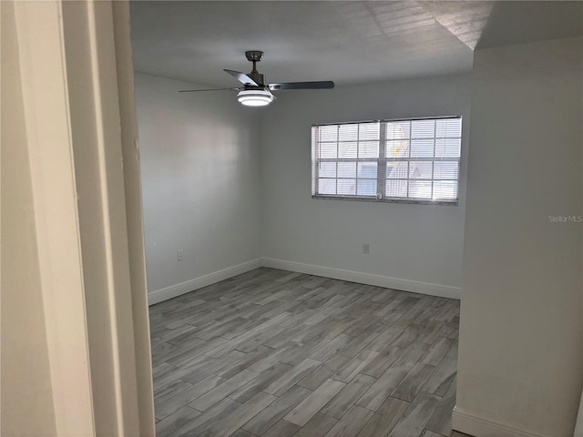 unfurnished room featuring baseboards, ceiling fan, and wood finished floors