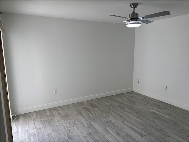 spare room with baseboards, a ceiling fan, and wood finished floors