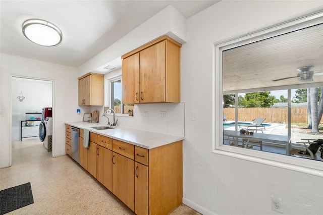 kitchen featuring a sink, washer / dryer, dishwasher, ceiling fan, and light countertops