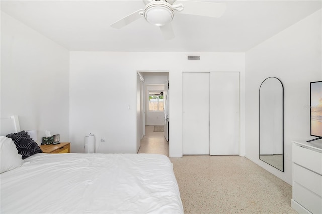 bedroom featuring ceiling fan, a closet, visible vents, and light speckled floor