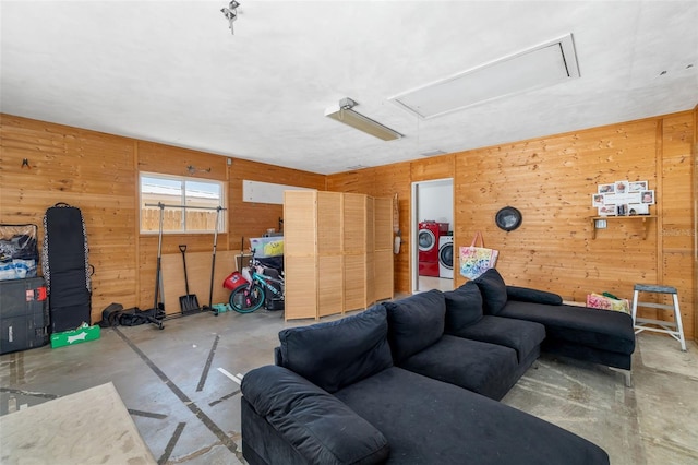 living room featuring attic access, wooden walls, and concrete flooring