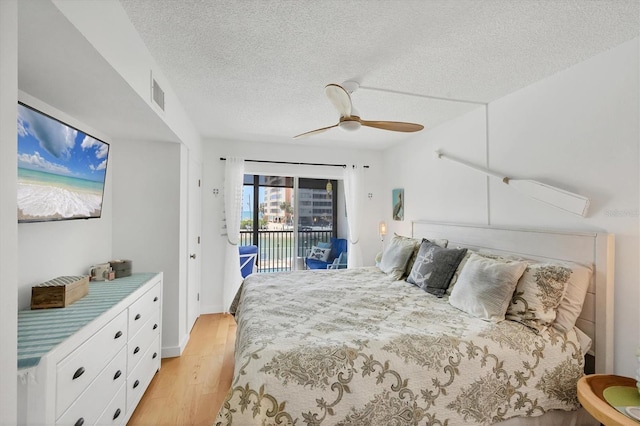 bedroom featuring access to exterior, visible vents, light wood-style flooring, a textured ceiling, and ceiling fan