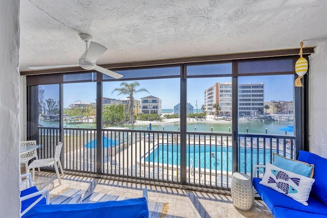 sunroom featuring a water view