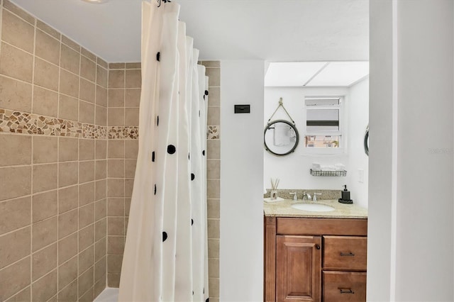 bathroom with vanity and tiled shower