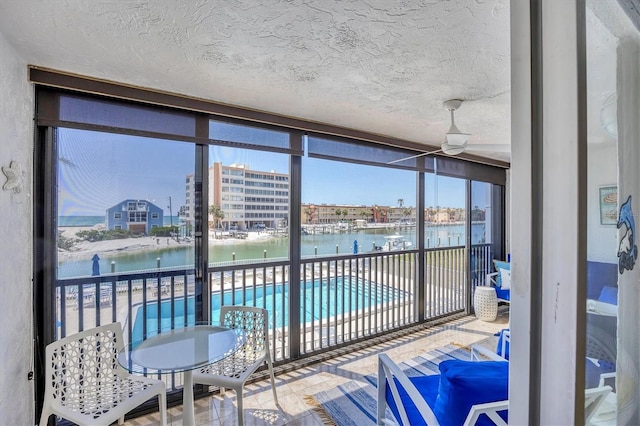 sunroom / solarium featuring a water view
