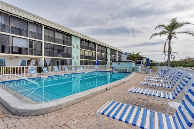 community pool with fence and a patio area