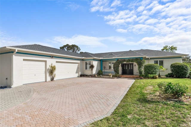 1828 Mova St, Sarasota, FL 34231 - ranch-style house with a garage, stucco siding, decorative driveway, and a front yard