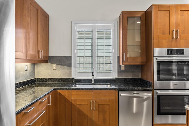 1828 Mova St, Sarasota, FL 34231 - kitchen with stainless steel appliances, a sink, brown cabinets, and dark stone countertops