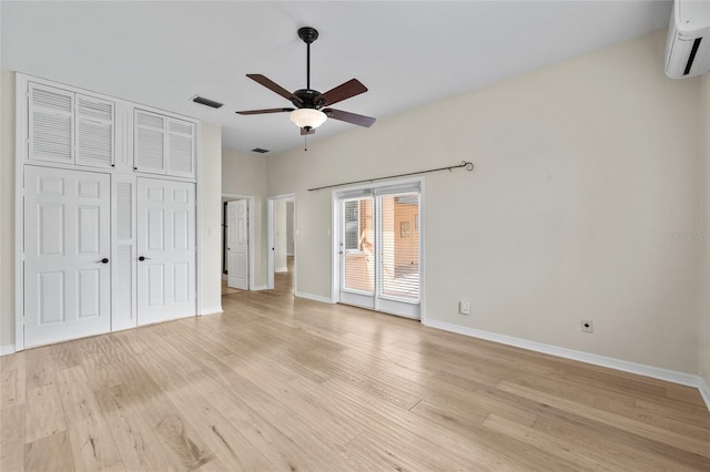 1828 Mova St, Sarasota, FL 34231 - unfurnished bedroom featuring a wall mounted air conditioner, baseboards, access to outside, and light wood-style flooring