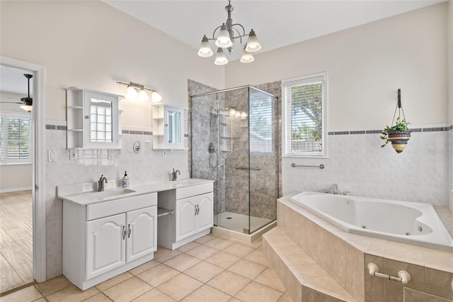 1828 Mova St, Sarasota, FL 34231 - bathroom featuring double vanity, a tub with jets, a stall shower, plenty of natural light, and a wainscoted wall