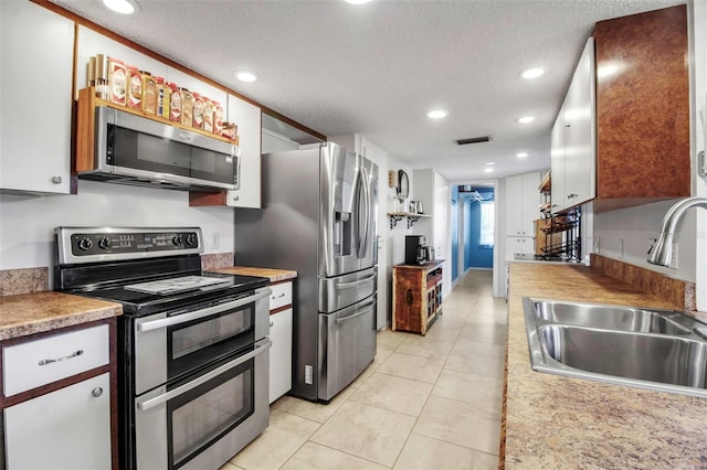 9011 Hilolo Ln, Venice, FL 34293 - kitchen featuring visible vents, white cabinets, a sink, appliances with stainless steel finishes, and a textured ceiling