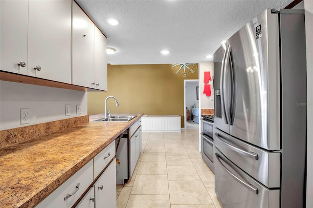 9011 Hilolo Ln, Venice, FL 34293 - kitchen featuring a sink, appliances with stainless steel finishes, a textured ceiling, white cabinetry, and radiator