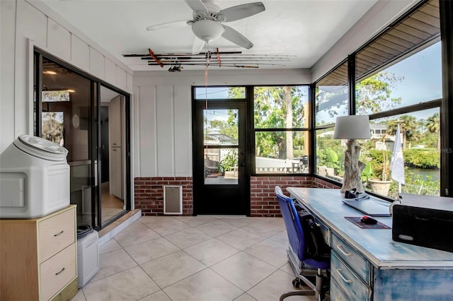 9011 Hilolo Ln, Venice, FL 34293 - unfurnished office with a healthy amount of sunlight, ceiling fan, brick wall, and light tile patterned floors