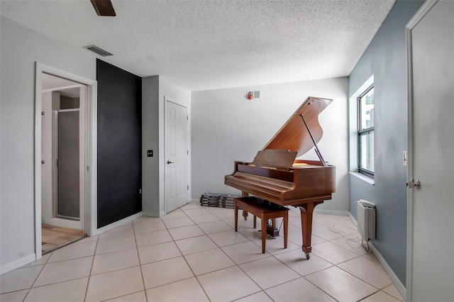 9011 Hilolo Ln, Venice, FL 34293 - sitting room with visible vents, baseboards, light tile patterned flooring, and a textured ceiling