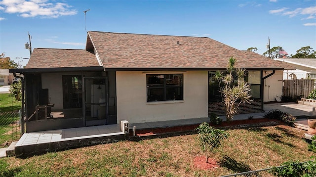 9011 Hilolo Ln, Venice, FL 34293 - rear view of house featuring a sunroom, a yard, stucco siding, fence, and a shingled roof