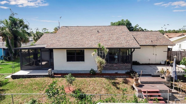 9011 Hilolo Ln, Venice, FL 34293 - view of front of house with a front lawn, a sunroom, a wooden deck, fence, and a shingled roof