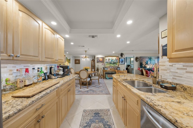 kitchen featuring light brown cabinets, a tray ceiling, a sink, and ornamental molding