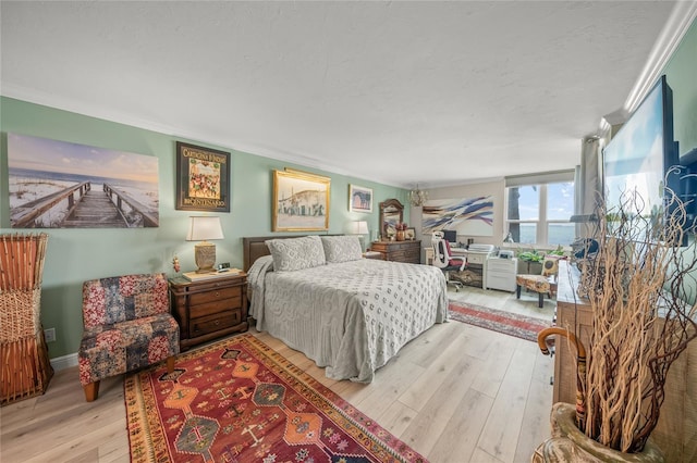 bedroom with baseboards, crown molding, hardwood / wood-style flooring, and a textured ceiling