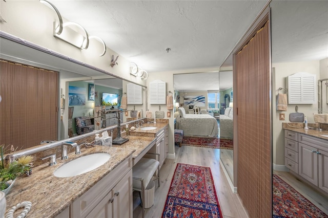 bathroom featuring ensuite bathroom, wood finished floors, and vanity