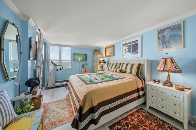 bedroom featuring ornamental molding and wood finished floors