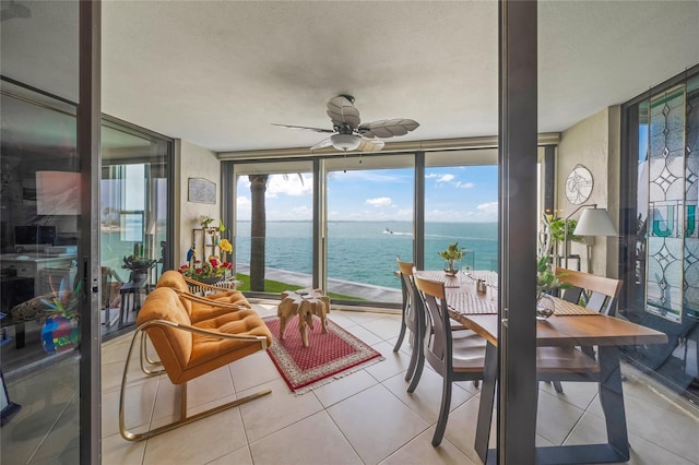 sunroom featuring a water view
