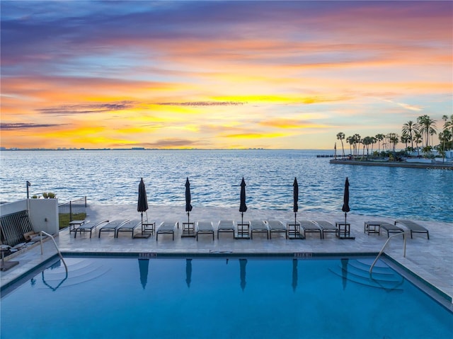 view of pool with a water view and a dock