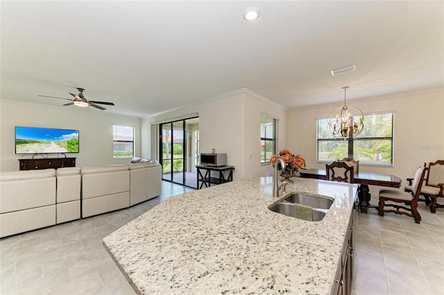 kitchen with a wealth of natural light, a sink, ornamental molding, and light tile patterned flooring