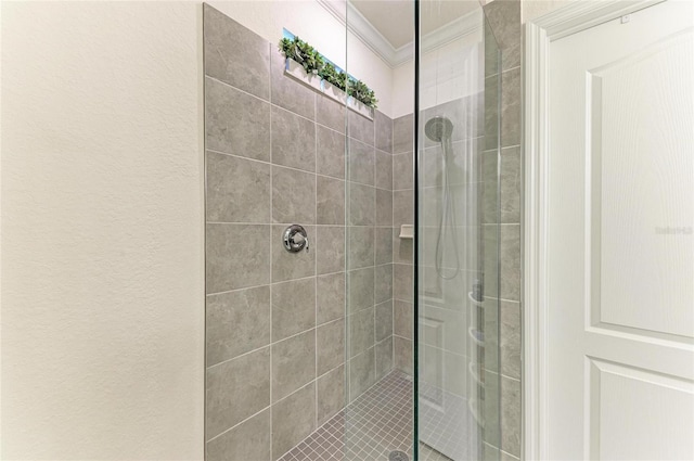 bathroom with crown molding and a stall shower
