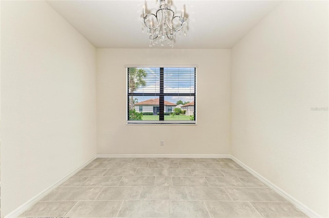 spare room featuring baseboards, a chandelier, and light tile patterned flooring