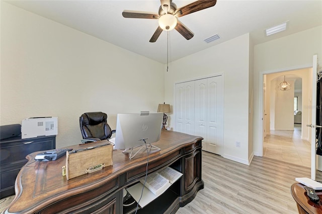 office area with baseboards, a ceiling fan, visible vents, and light wood-type flooring