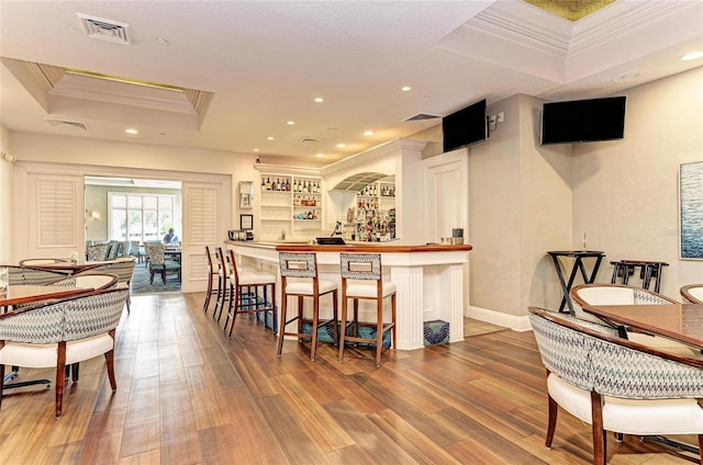 bar with visible vents, recessed lighting, a raised ceiling, and ornamental molding