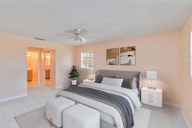 bedroom featuring visible vents, carpet floors, baseboards, ensuite bathroom, and ceiling fan