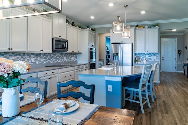 11702 Tetrafin Dr, Riverview, FL 33579 - kitchen featuring stainless steel appliances, decorative backsplash, crown molding, a center island with sink, and light countertops