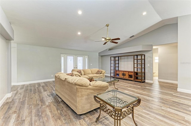 living room with ceiling fan, vaulted ceiling, baseboards, and light wood finished floors