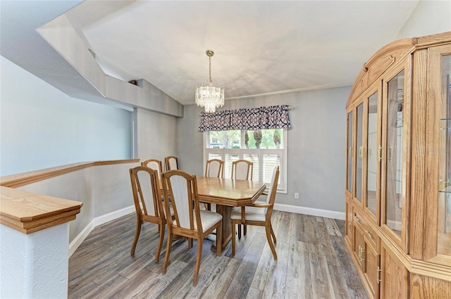 dining room featuring baseboards, a notable chandelier, and wood finished floors