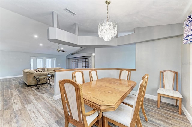 dining room with baseboards, visible vents, light wood finished floors, and ceiling fan with notable chandelier
