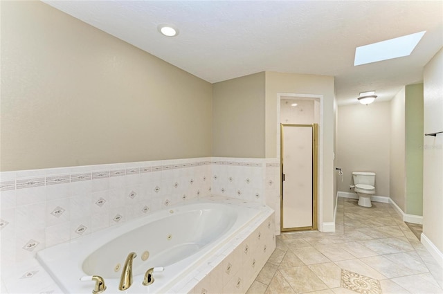 full bathroom featuring a skylight, tile patterned flooring, a shower stall, a whirlpool tub, and toilet