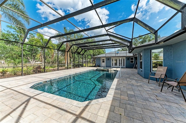 view of pool with a lanai, a patio, a pool with connected hot tub, and french doors