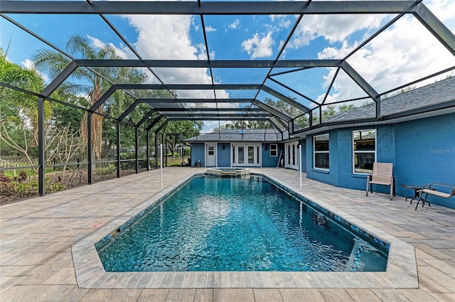 view of swimming pool featuring french doors, a patio, a pool with connected hot tub, and glass enclosure