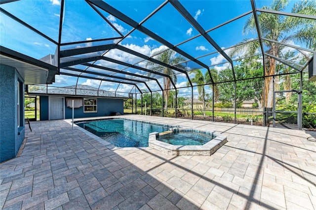 view of swimming pool featuring a patio area, glass enclosure, and a pool with connected hot tub