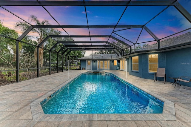 view of pool with a patio area, glass enclosure, french doors, and a pool with connected hot tub