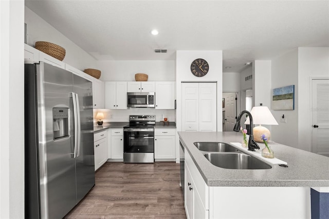 1800 Little Bird Ct, Sarasota, FL 34235 - kitchen featuring stainless steel appliances, dark wood-style flooring, an island with sink, white cabinets, and recessed lighting