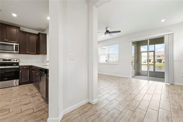 5543 Pleasantview Ct, Bradenton, FL 34211 - kitchen with dark brown cabinets, ceiling fan, wood finish floors, light countertops, and appliances with stainless steel finishes