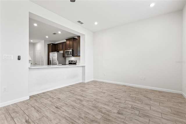 5543 Pleasantview Ct, Bradenton, FL 34211 - unfurnished living room featuring visible vents, a sink, baseboards, light wood finished floors, and recessed lighting