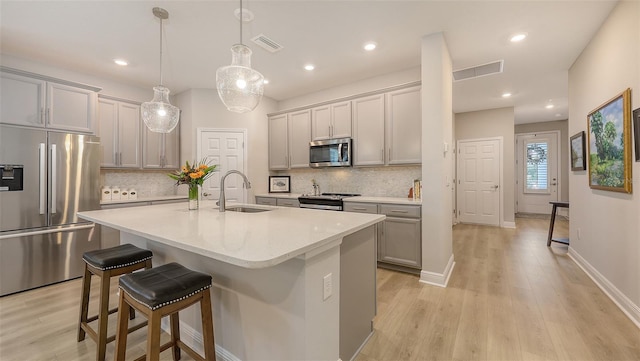 8110 Trimbelle Ter, Parrish, FL 34219 - kitchen with stainless steel appliances, a kitchen breakfast bar, light wood-type flooring, backsplash, and recessed lighting