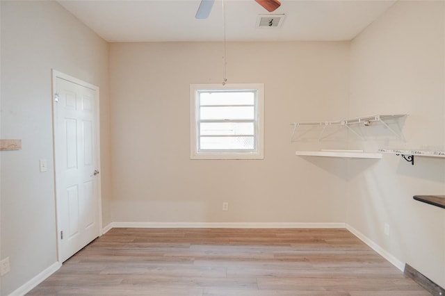 interior space featuring light wood-style flooring, visible vents, baseboards, and ceiling fan