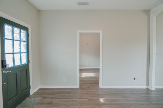 entrance foyer with baseboards, wood finished floors, and visible vents