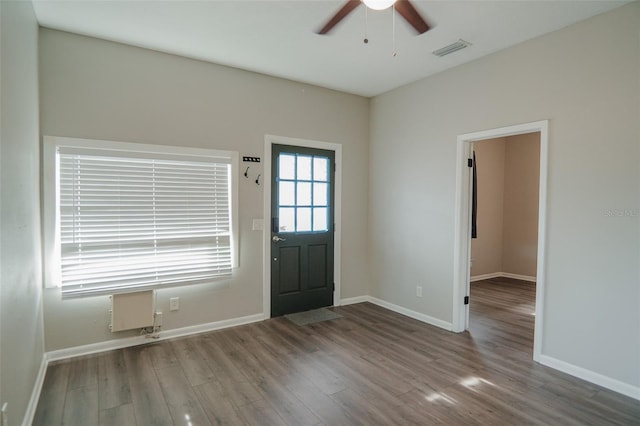 entrance foyer with wood finished floors, baseboards, a ceiling fan, and visible vents