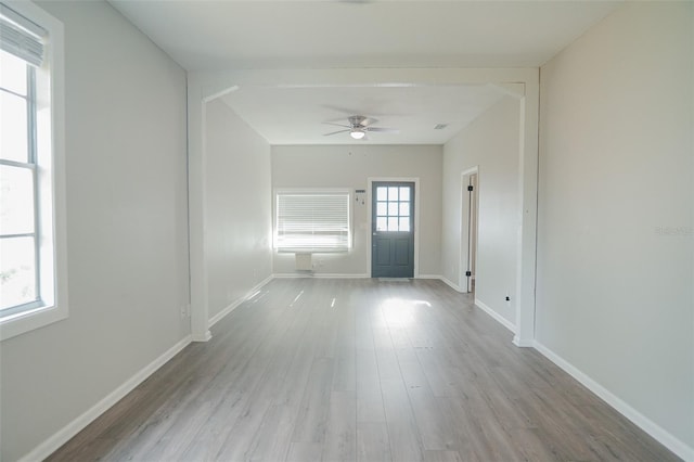 empty room with baseboards, a ceiling fan, and wood finished floors